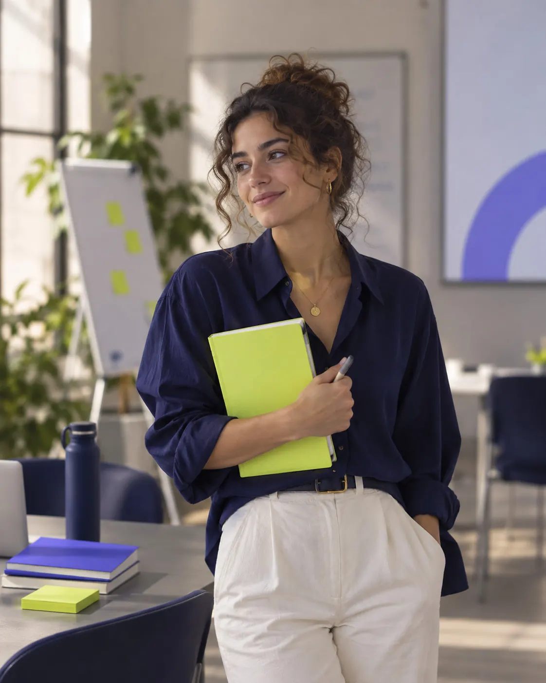 An ICAP facilitator holding a notebook in a sunlit training room